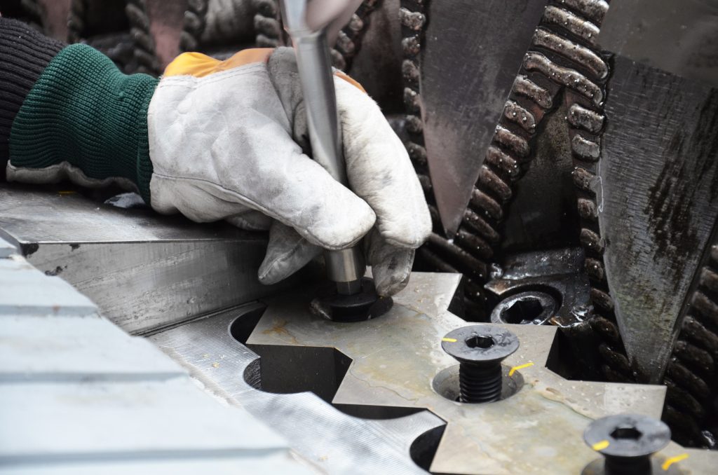 a technician tightens a bolt on a WEIMA machine