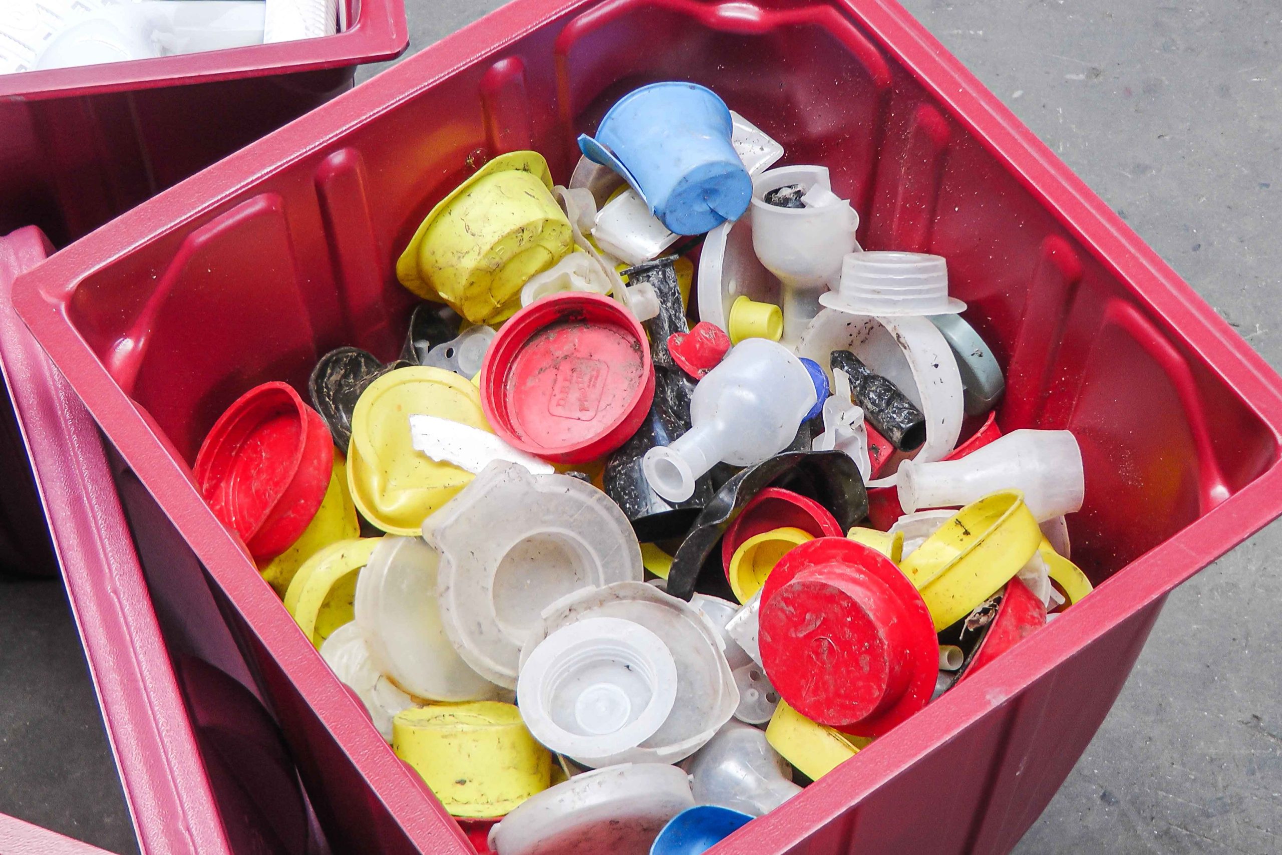 A red box with colorful containers of medical waste