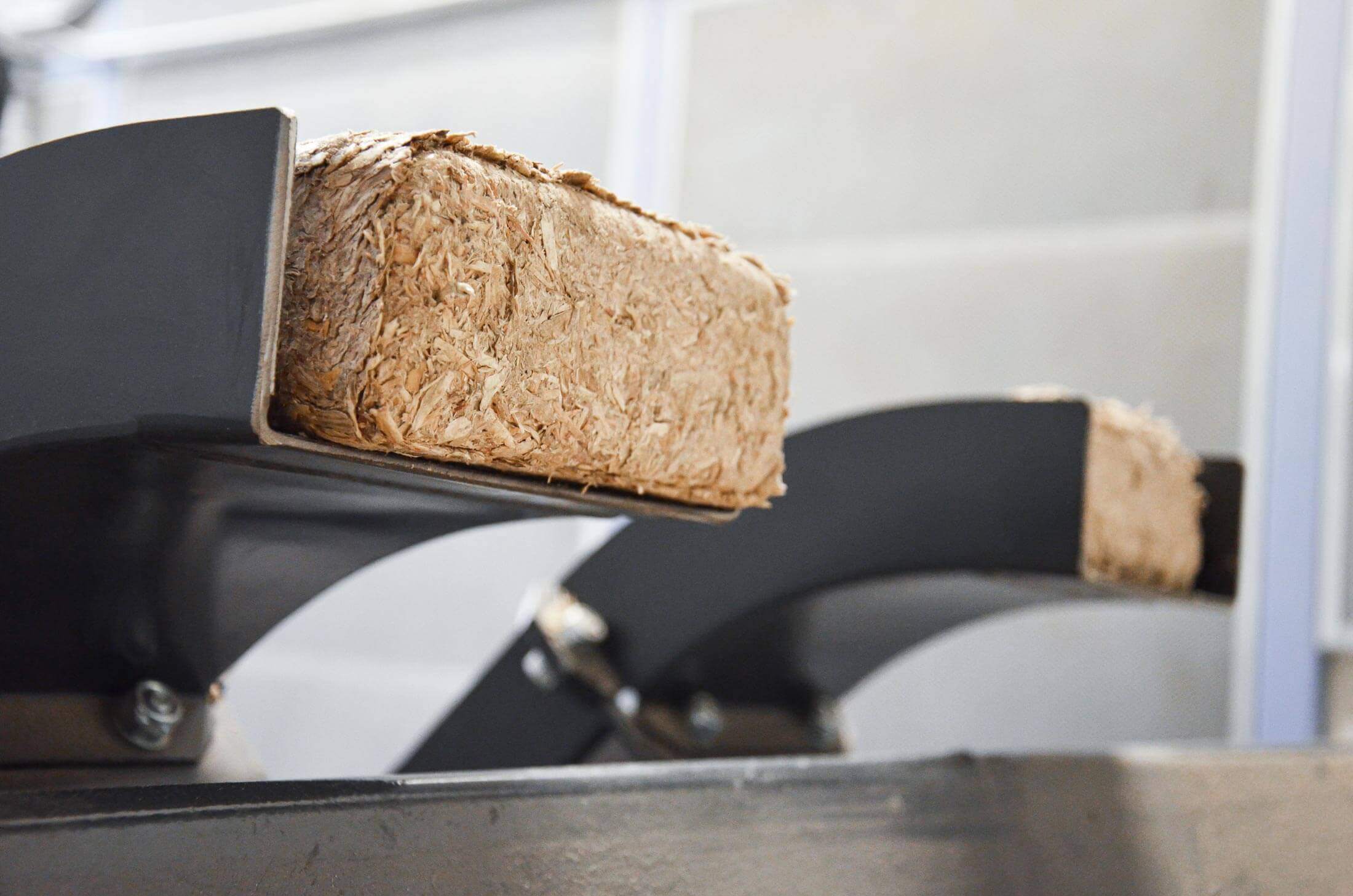 rectangular wood briquettes being discharged from briquetting machine