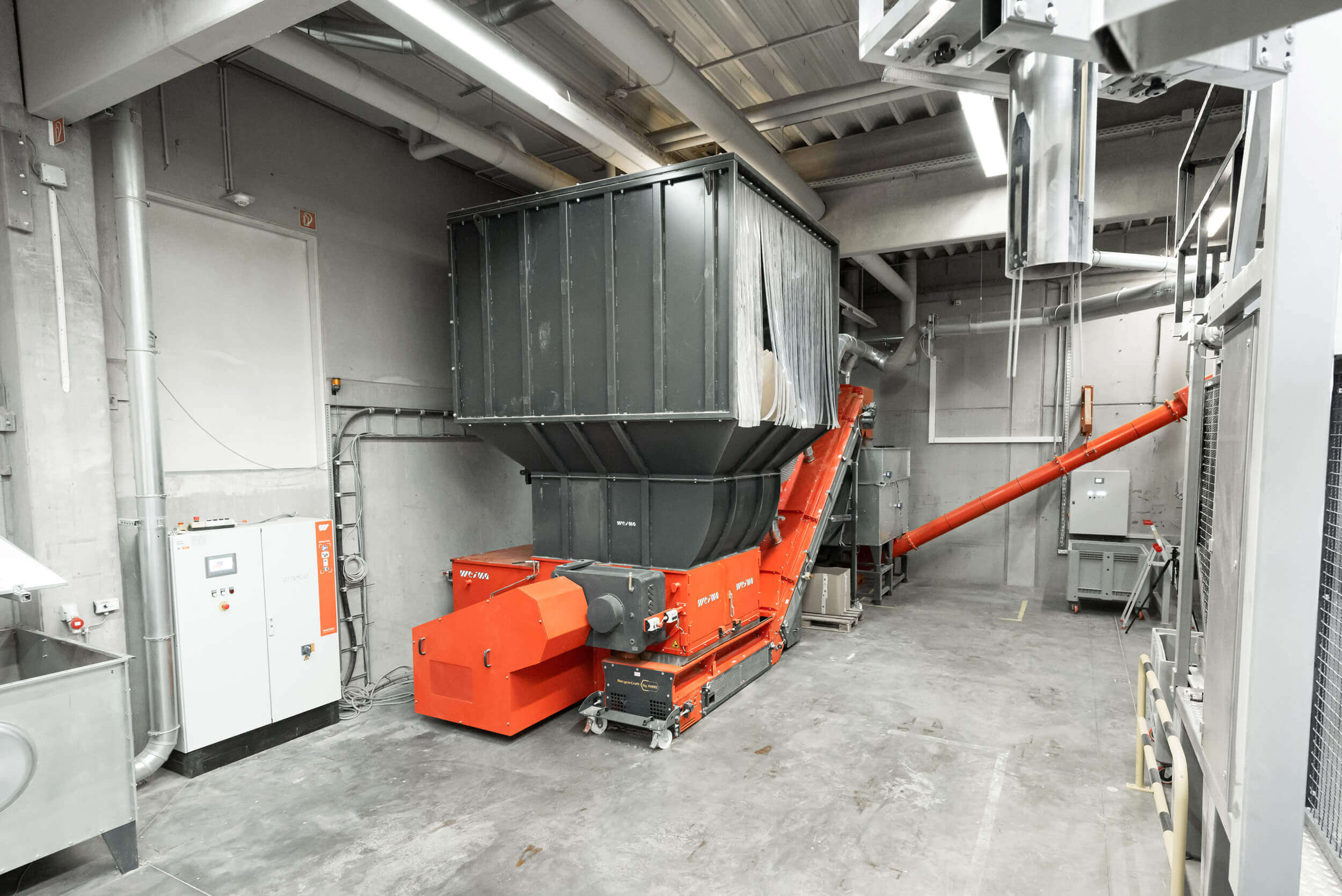 WEIMA lieferte eine Systemlösung mit Shredder, geschlossenem Förderband, Absaugstutzen, Dosieranlage