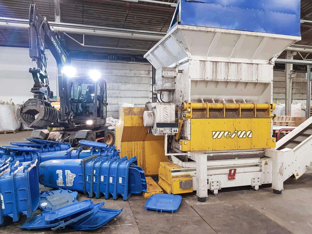trash bins being shredded in a weima shredder