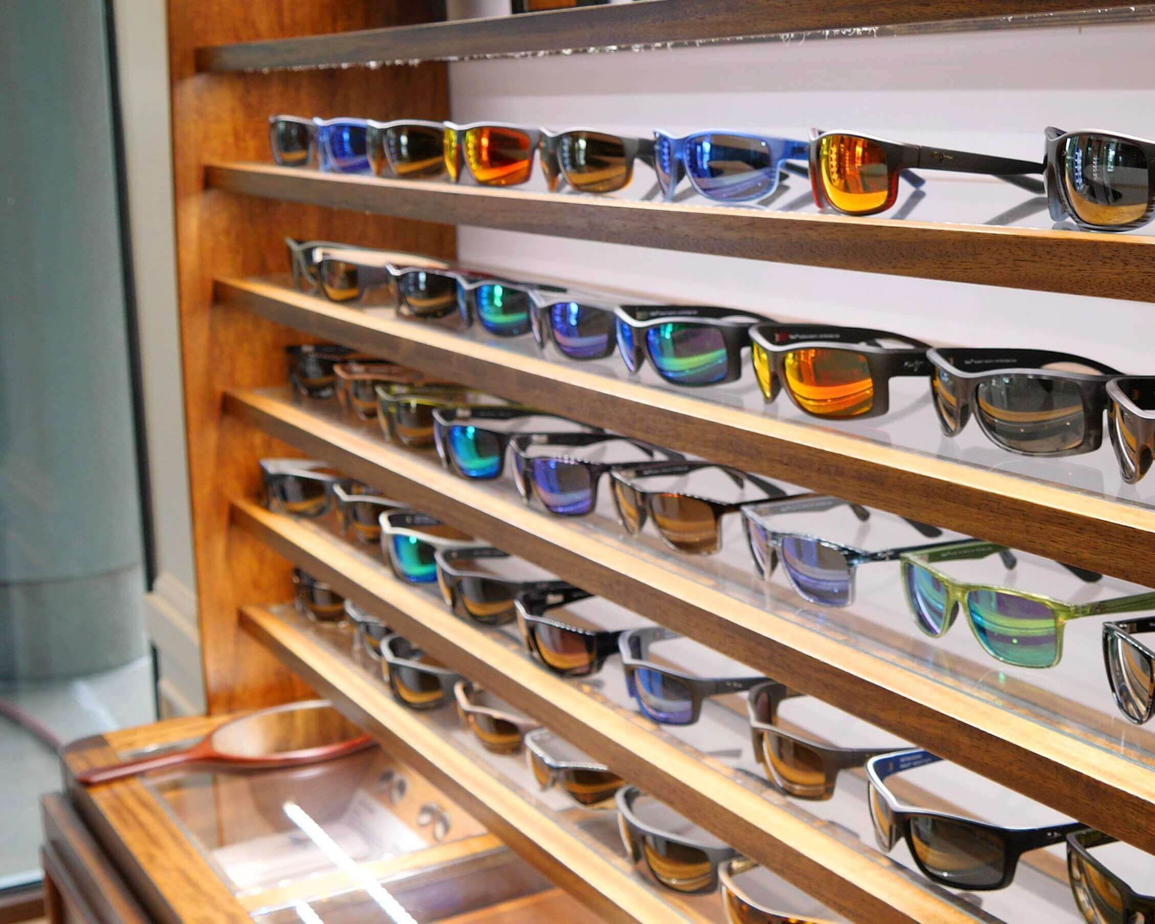 High-end Maui Jim sunglasses lined up on a display shelf in their showroom