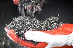 Shredded Aluminum chips in hands with glove