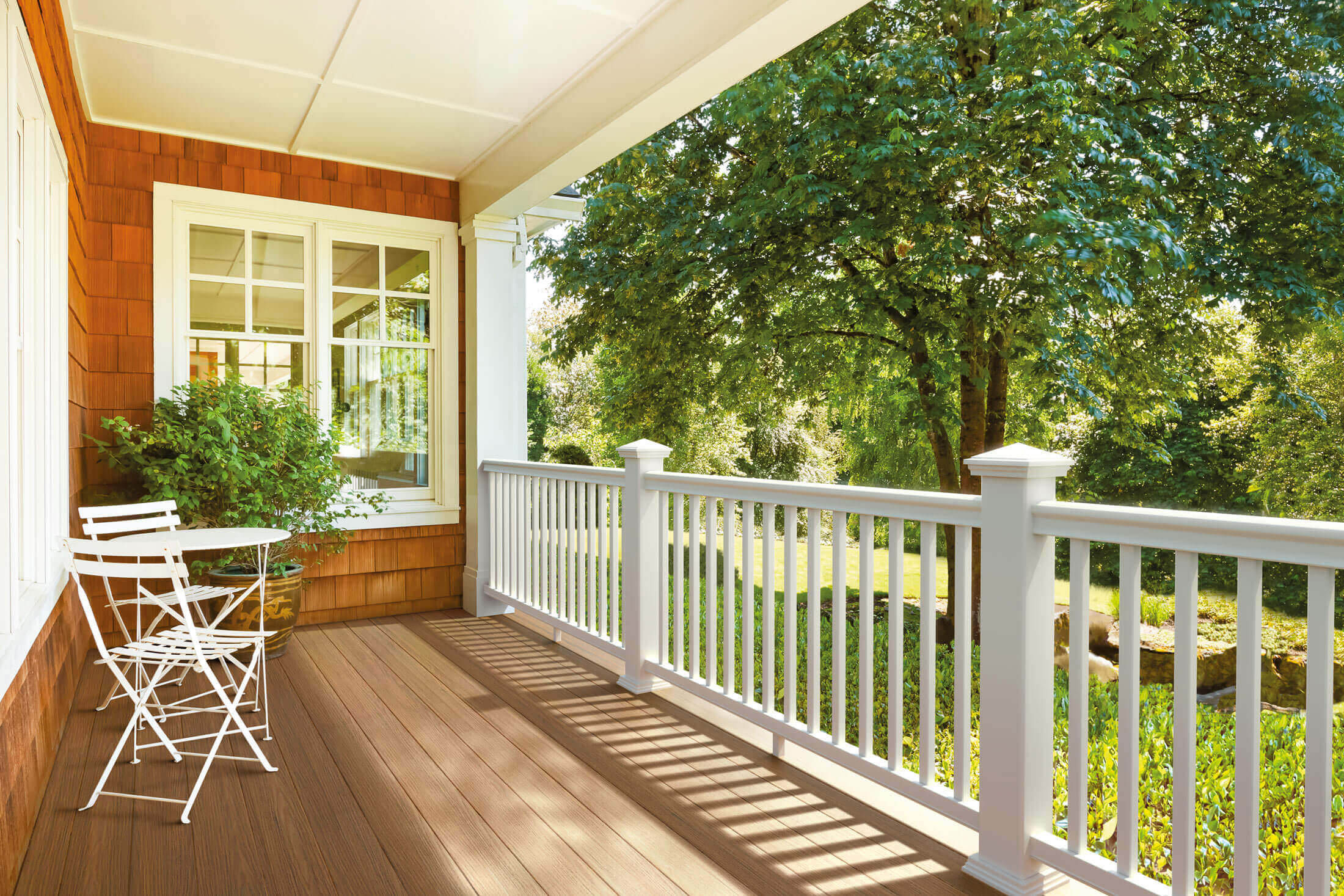 a front porch with composite decking and a white railing