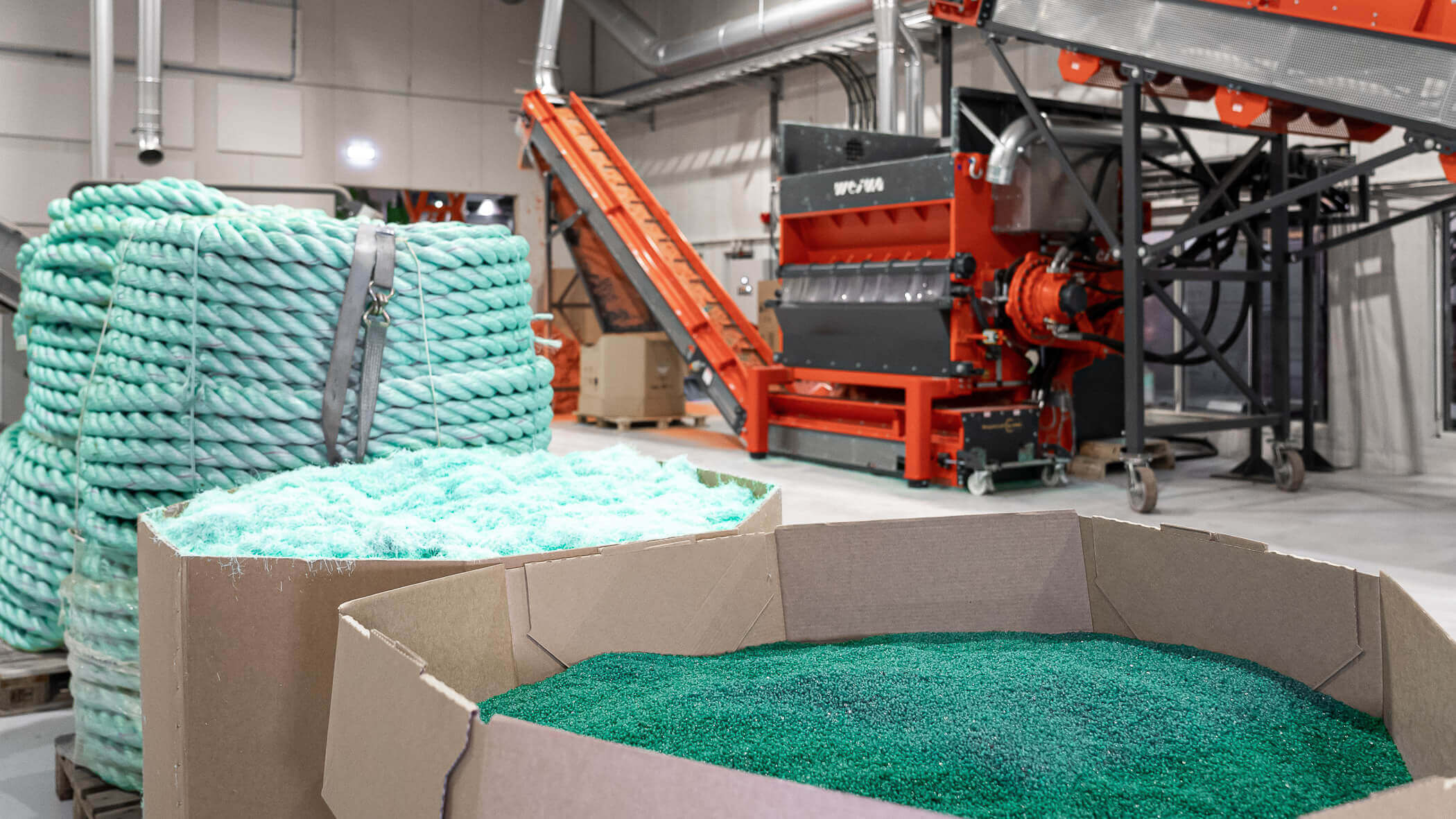 shredded, granulated and extruded fishing ropes in front of a weima shredder