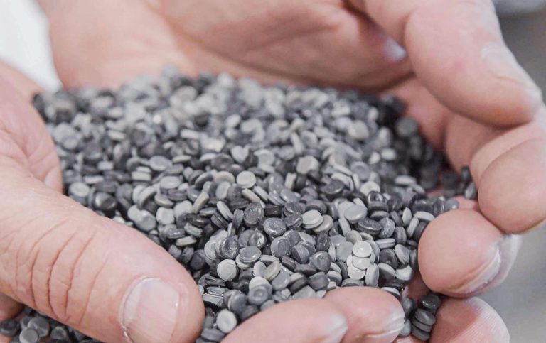 Hands holding a handful of plastic granulate