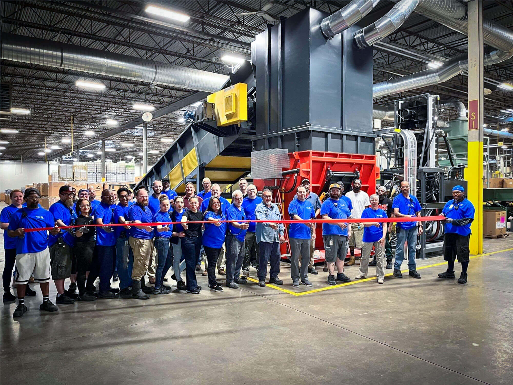 butler macdonald employees in front of a big weima shredder inside a production hall