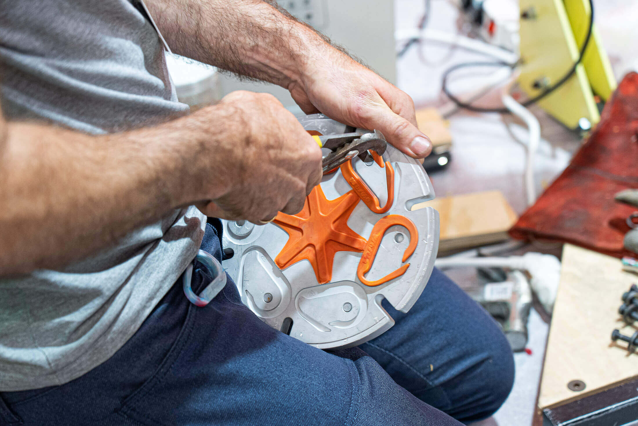 Precious Plastic employee takes out recycled carabiners from aluminum mould