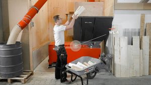 employee fedding the weima wood chipper manually with wood waste
