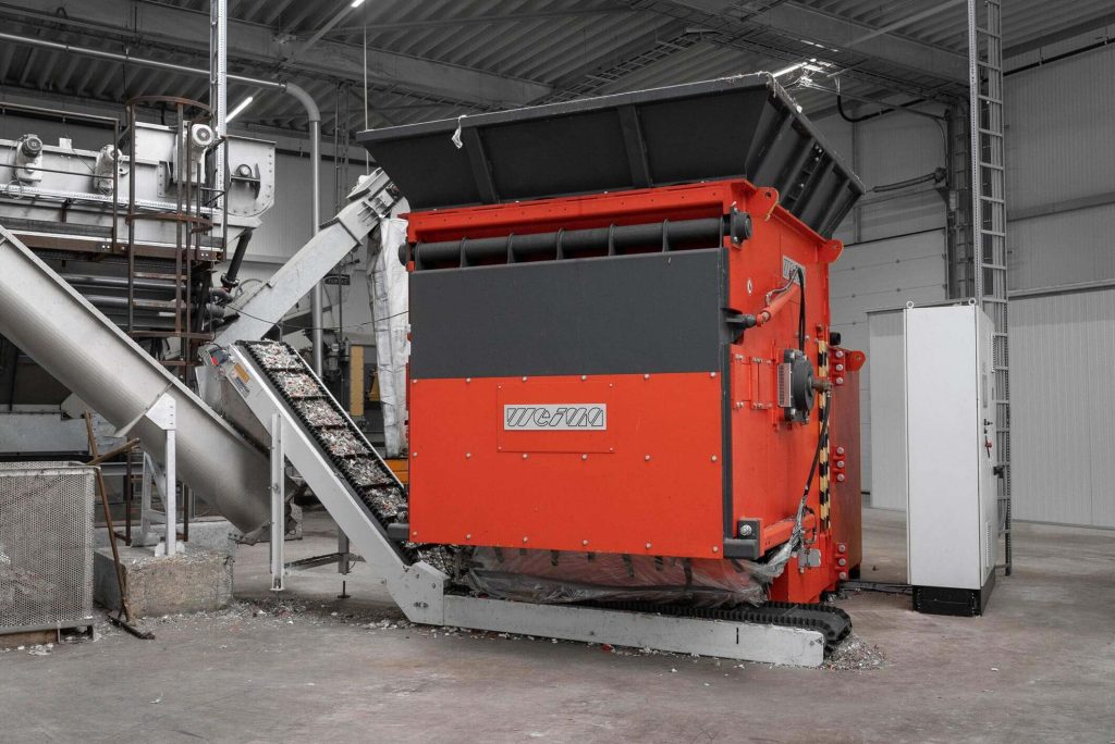 orange WEIMA S7.20 single-shaft shredder with conveyor belt at Stiphout Plastics in the Netherlands