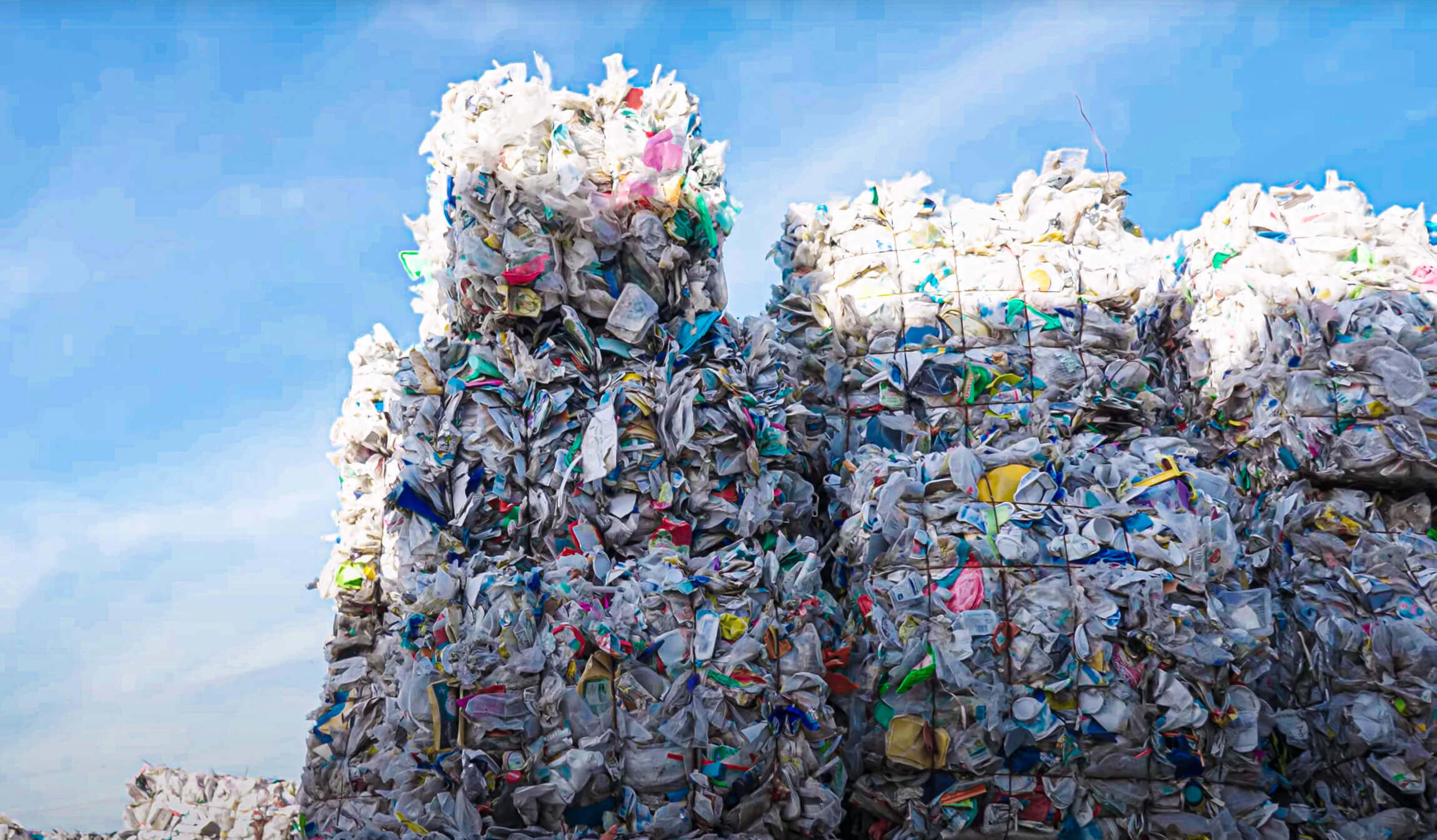 baled post-consumer trash outdoor with blue sky