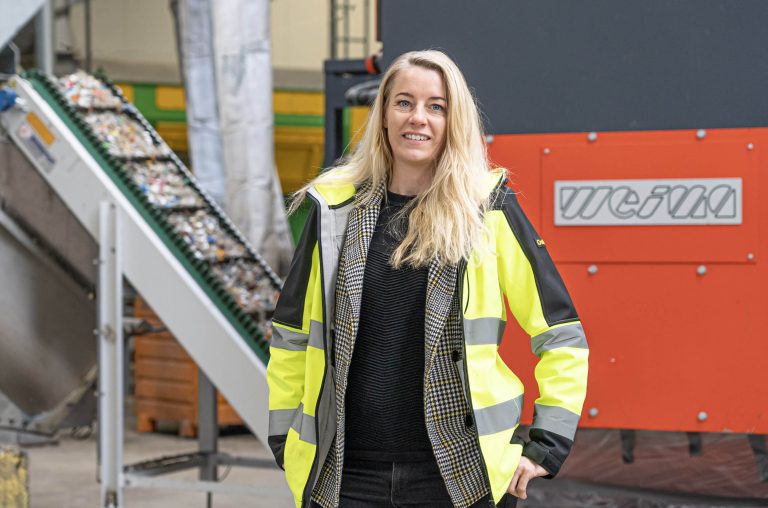 woman in front of a weima shredder