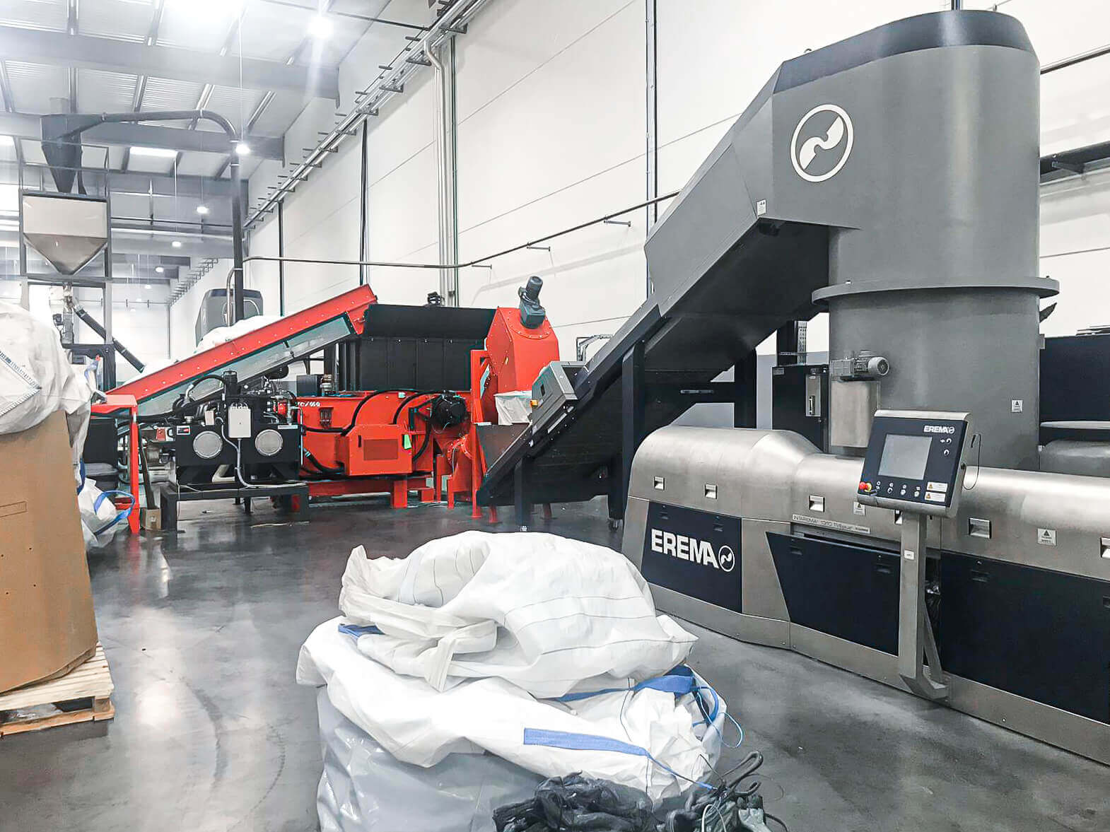 WEIMA shredder feeding an Erema extrusion system via conveyor belt