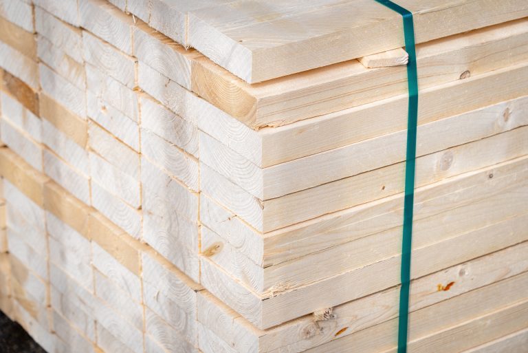 A stack of glued laminated timber held together by a conveyor belt"