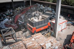 WEIMA M8.28 two-shaft pre-shredder for household waste in Italy surrounded by piles of waste