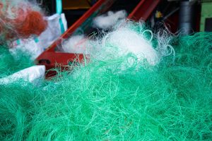 Used fishing net and ghost nets in front of a conveyor belt