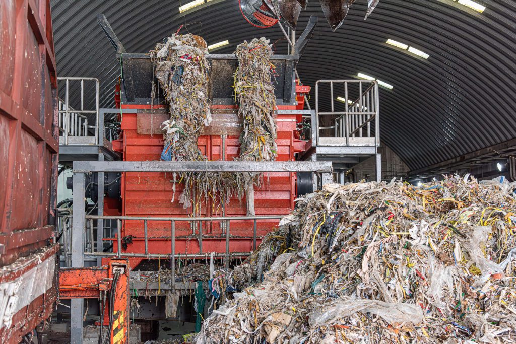 WEIMA PreCut 2500 shreds pulper waste from paper recycling process and is loaded by crane