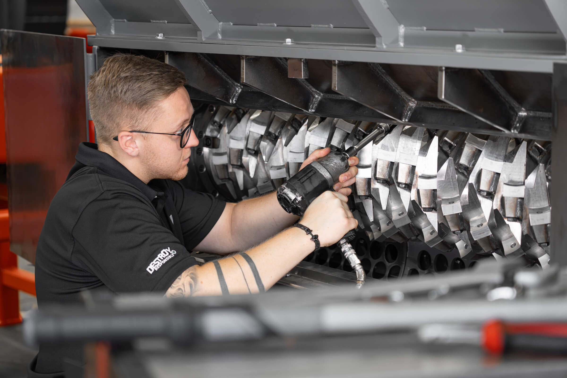 Worker in front of a shredder with rotor, assembling rotor knives