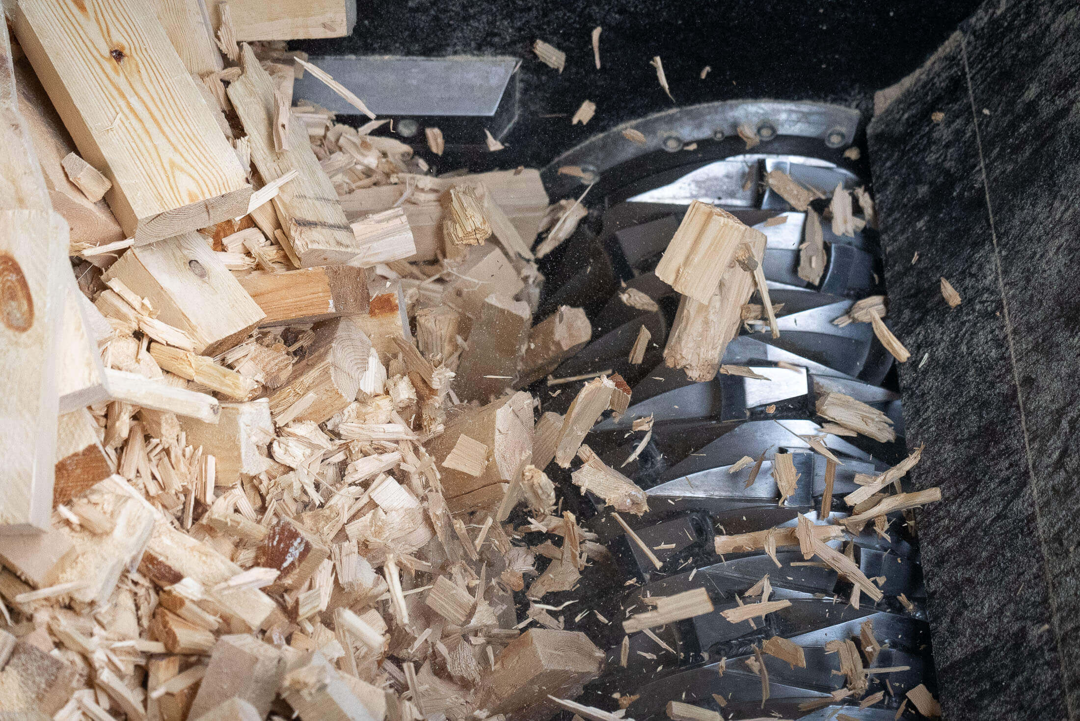 A rotor shreds the wood blocks and wood residues.