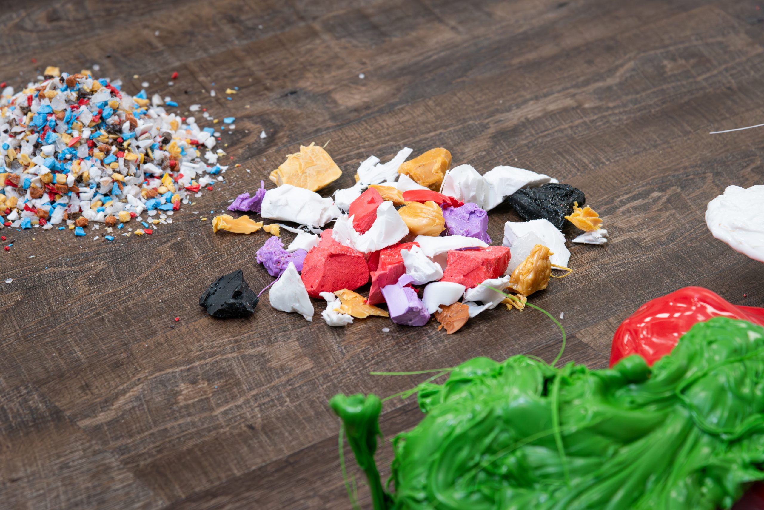 three piles of plastic material: purge, shredded purge and granulated purge