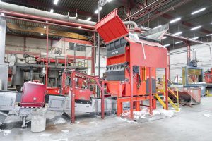 Plastic film shredder with conveyor belt inside a production halle
