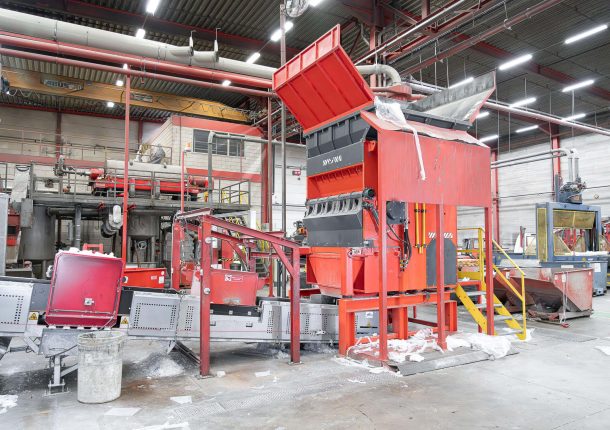 Plastic film shredder with conveyor belt inside a production halle