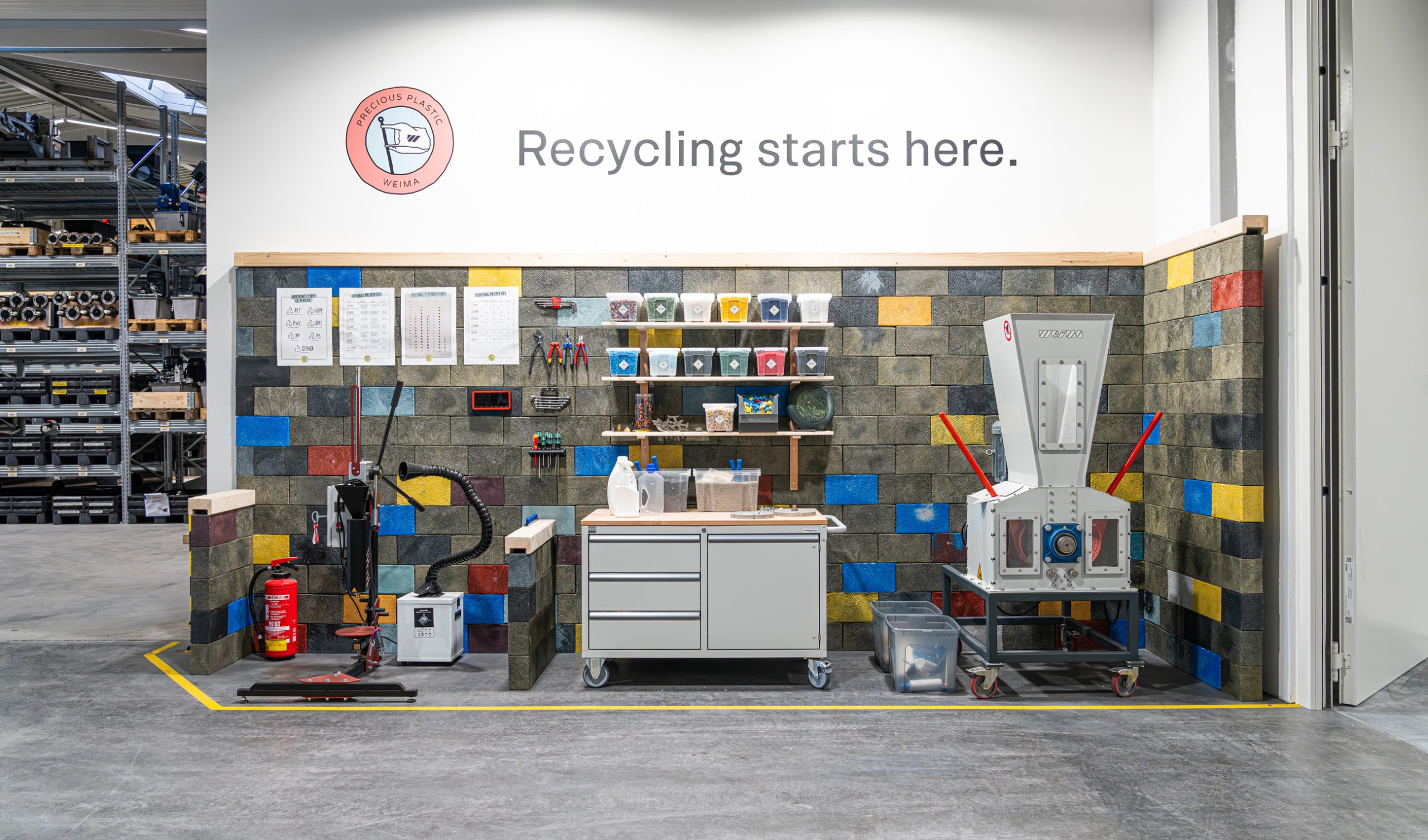 Precious plastic workspace at WEIMA headquarters with shredder and injection molding machine