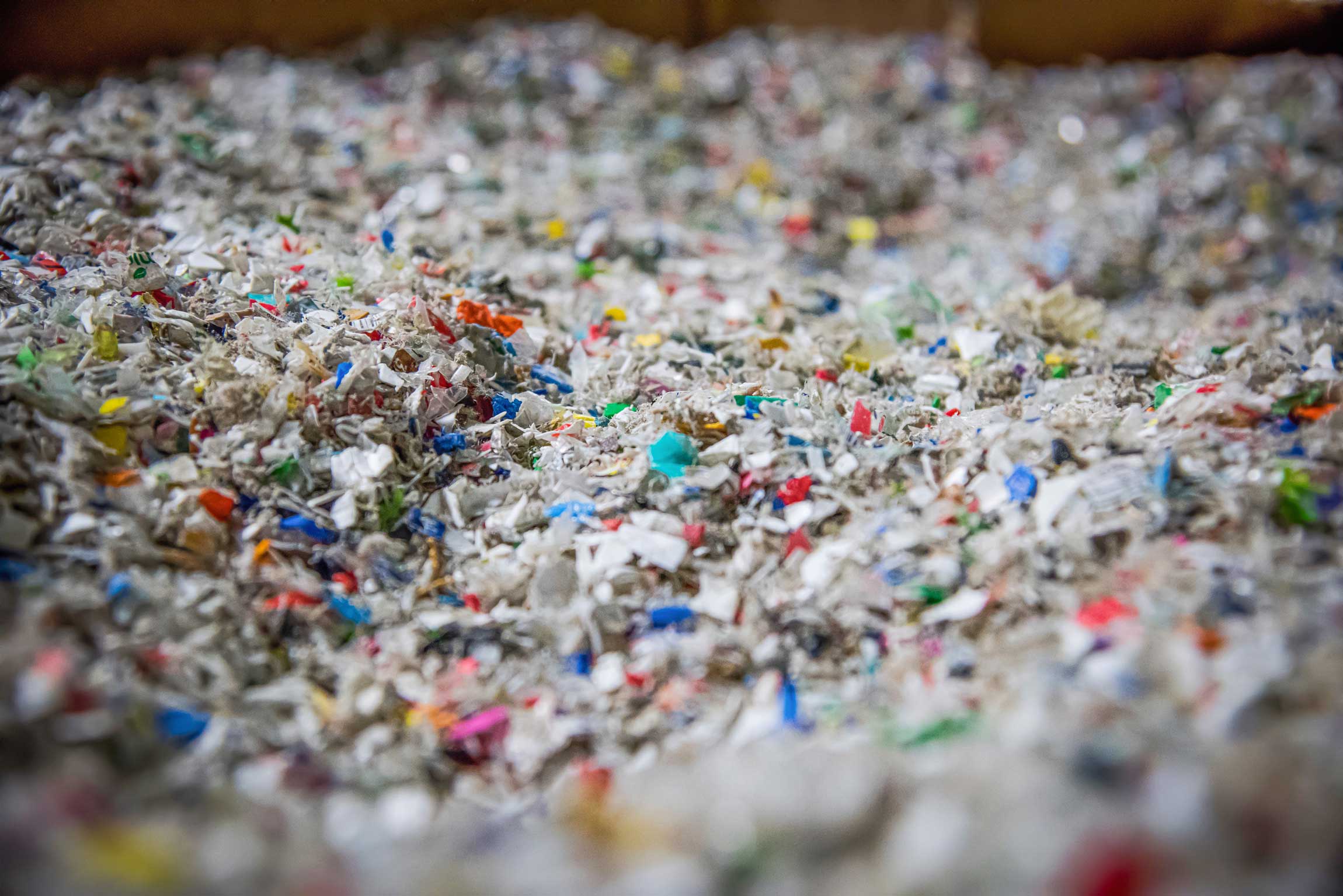 Mit WEIMA Shredder zerkleinerte bunte Kunstoff Flakes in einem Behälter