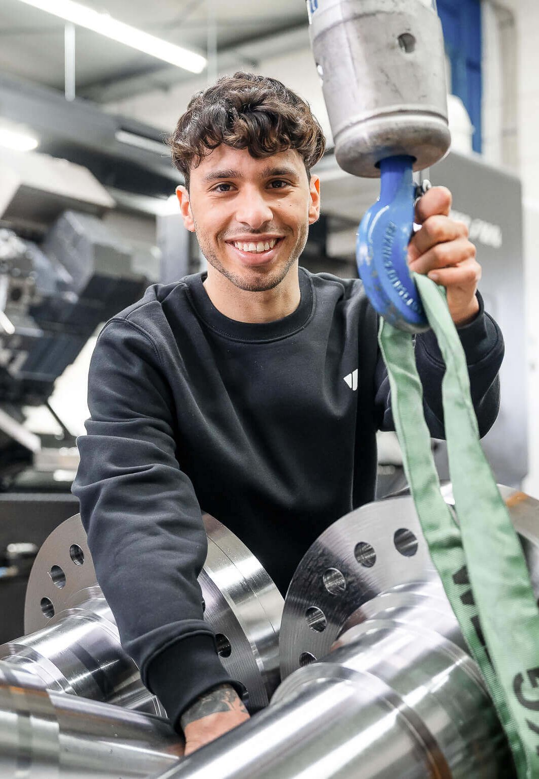 Smiling WEIMA employee in front of a CNC milling machine