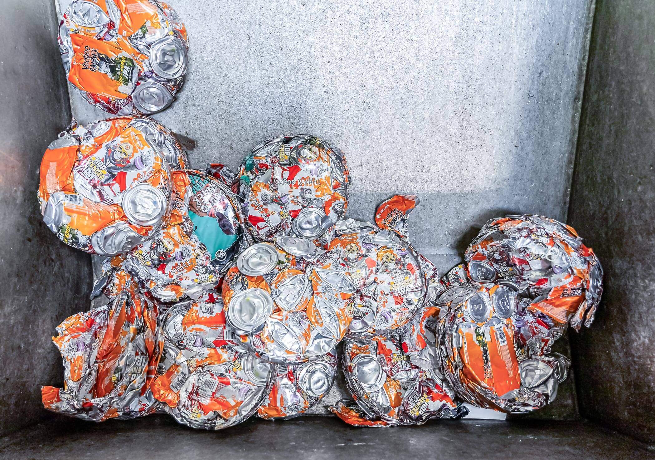 Crushed and compressed cans in a bin.