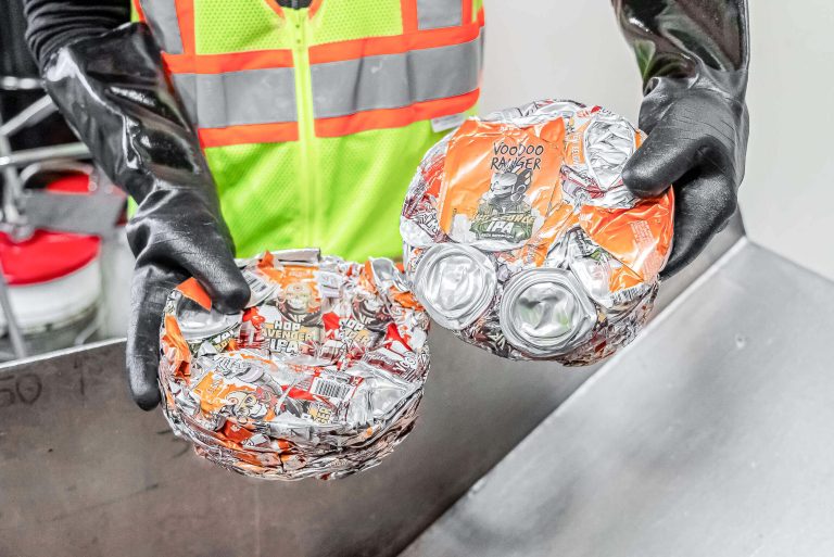 An employee holding two discs of compressed cans.