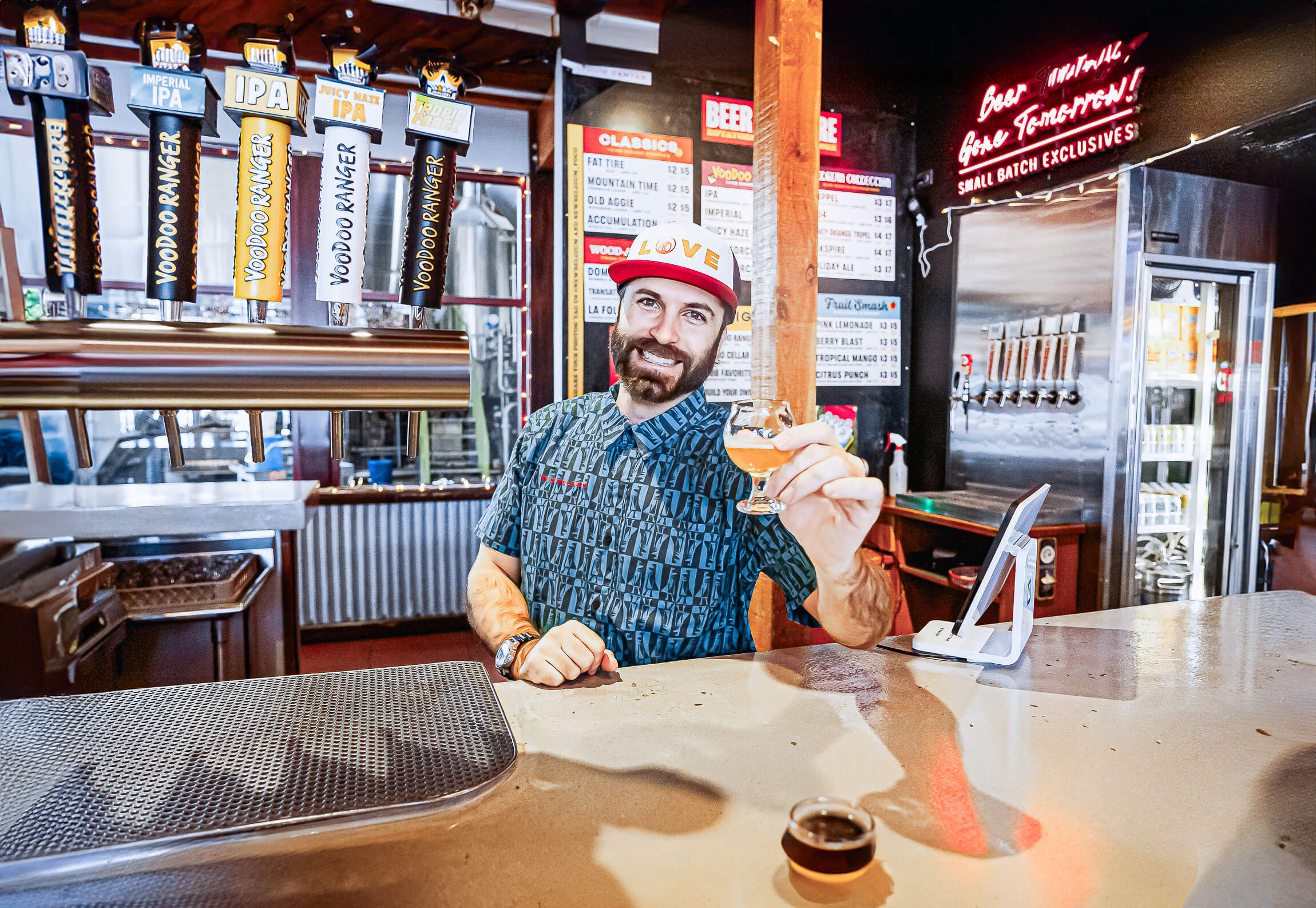 Man smiling with drink in hand.