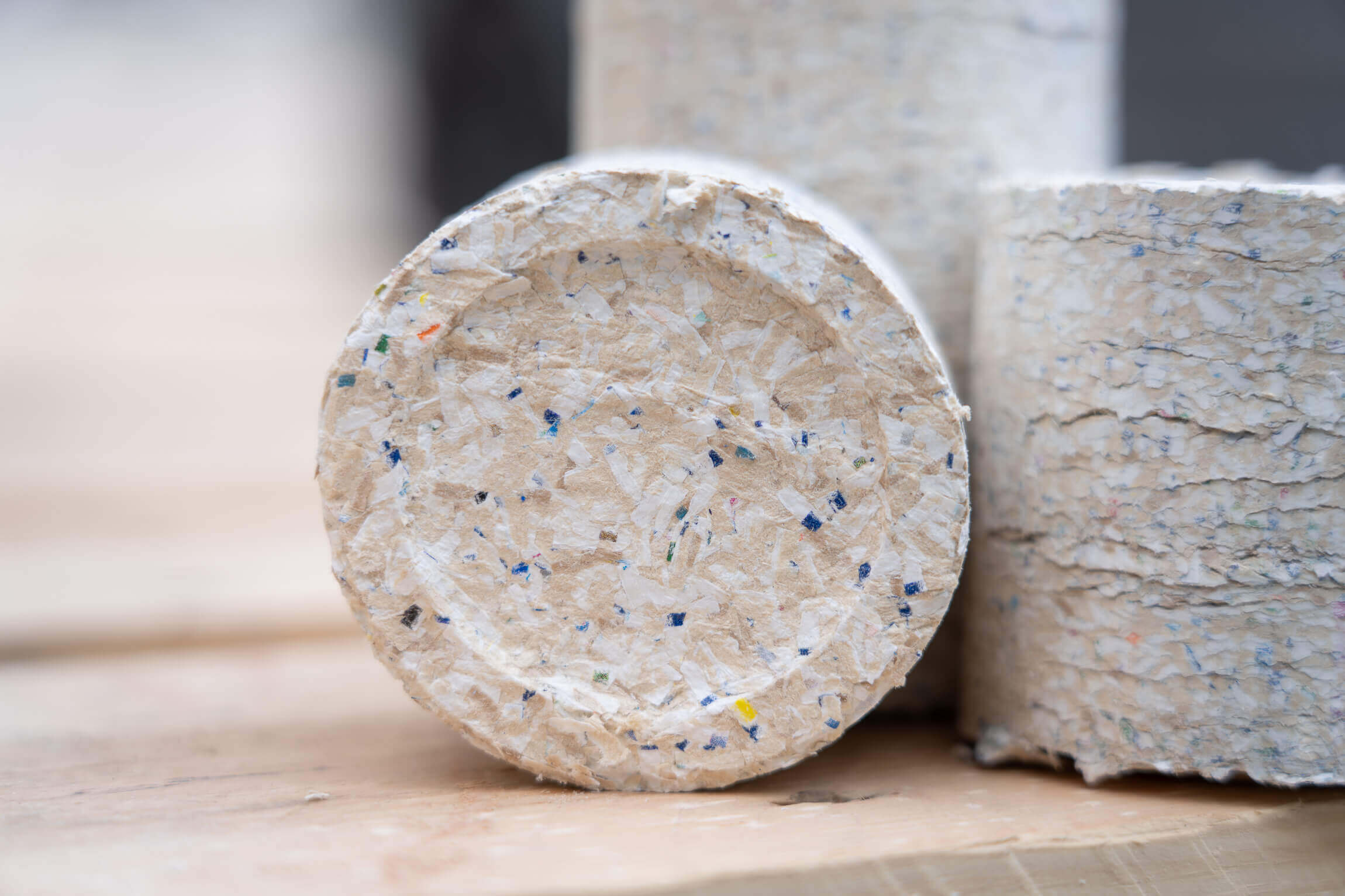 3 white briquettes with color particles from paper scraps and dust