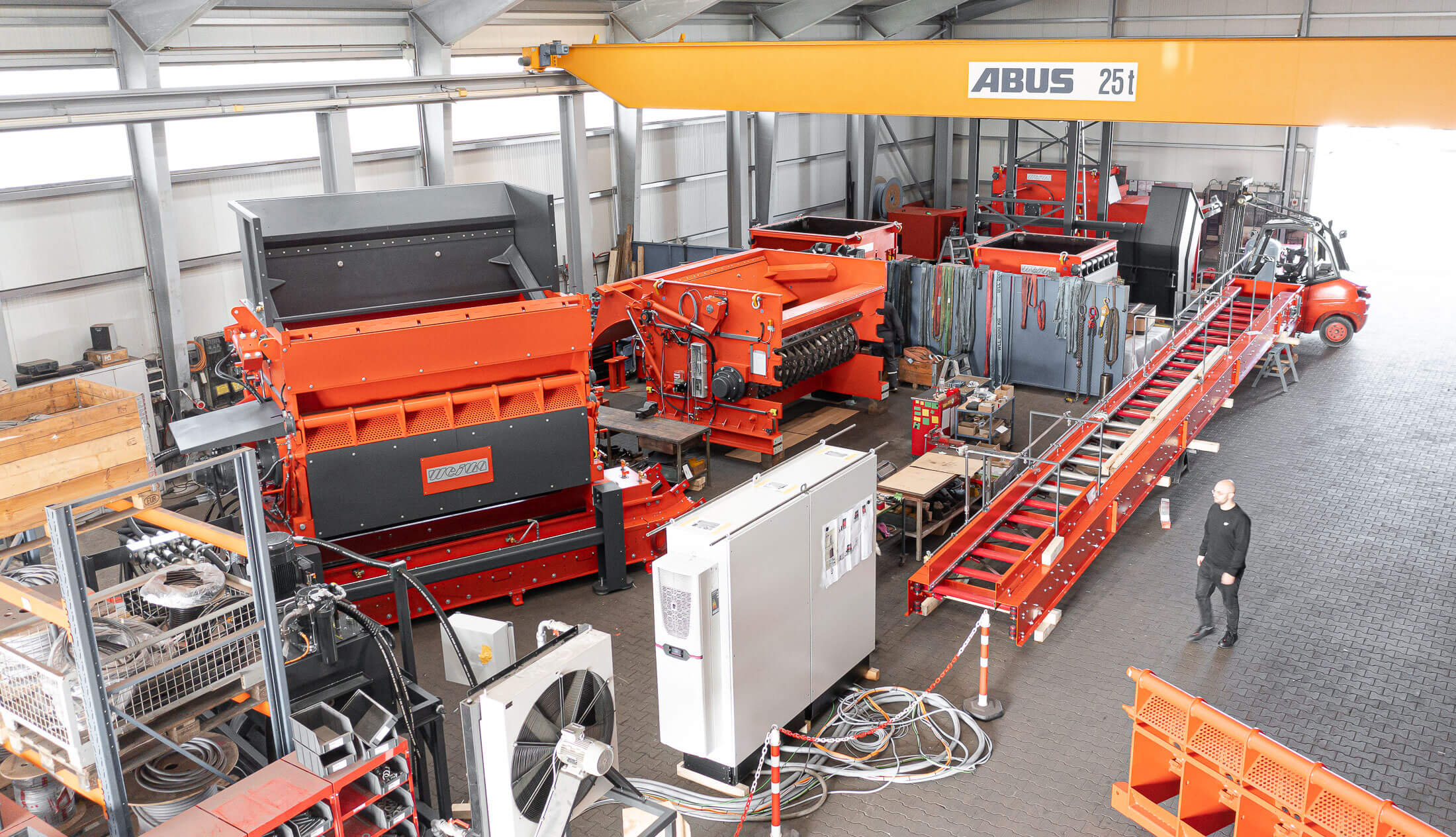Several orange WEIMA shredders standing in line at final assembly hall in WEIMA Saxony-Anhalt production site