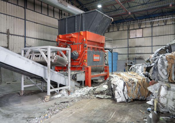 WEIMA PowerLine shredder in production hall with subsequent conveyor belt