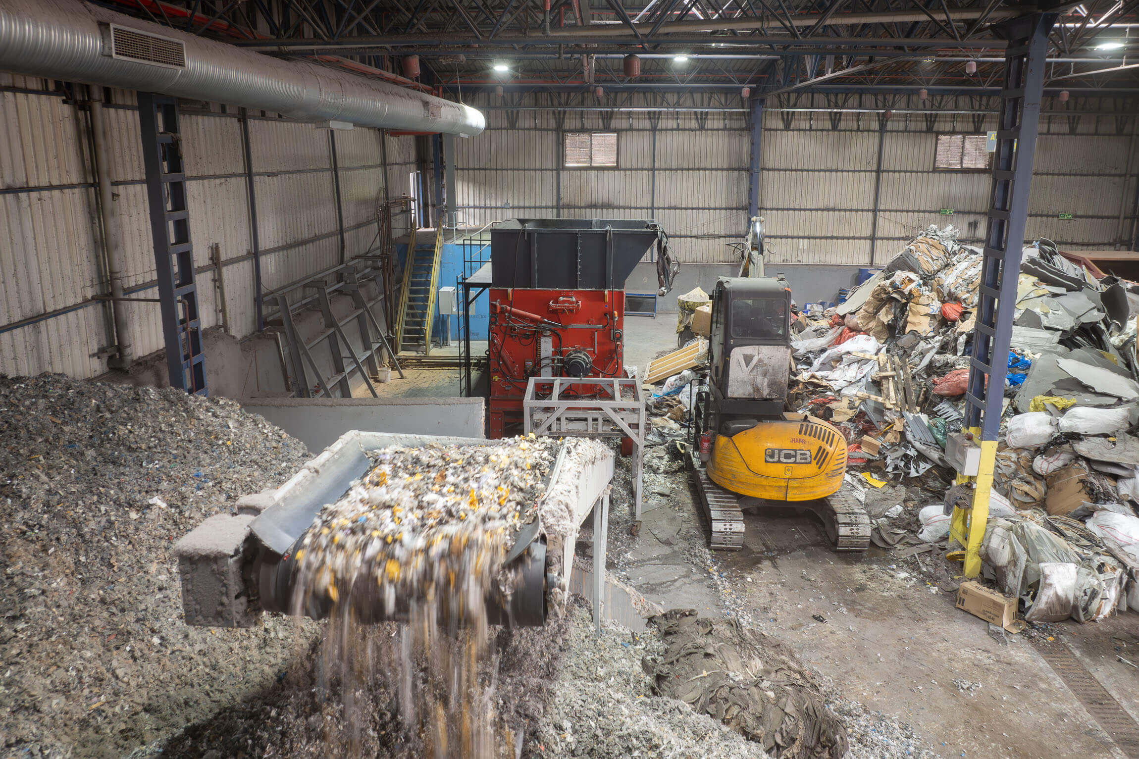 Shredded waste is transported via a conveyor belt