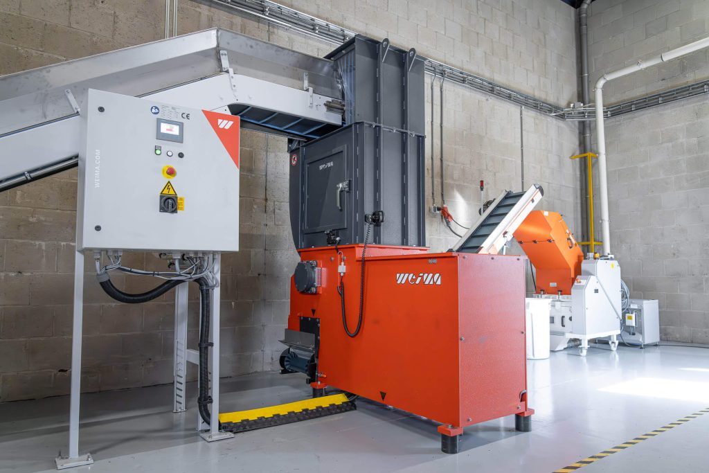 WEIMA WLK 4 single-shaft shredder at Record Industry, next to a Wanner granulator and conveyor belts