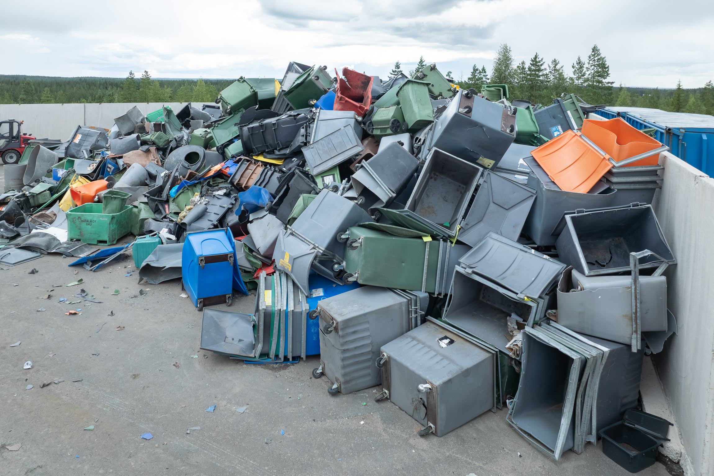 A mountain of old garbage cans at a recycling center