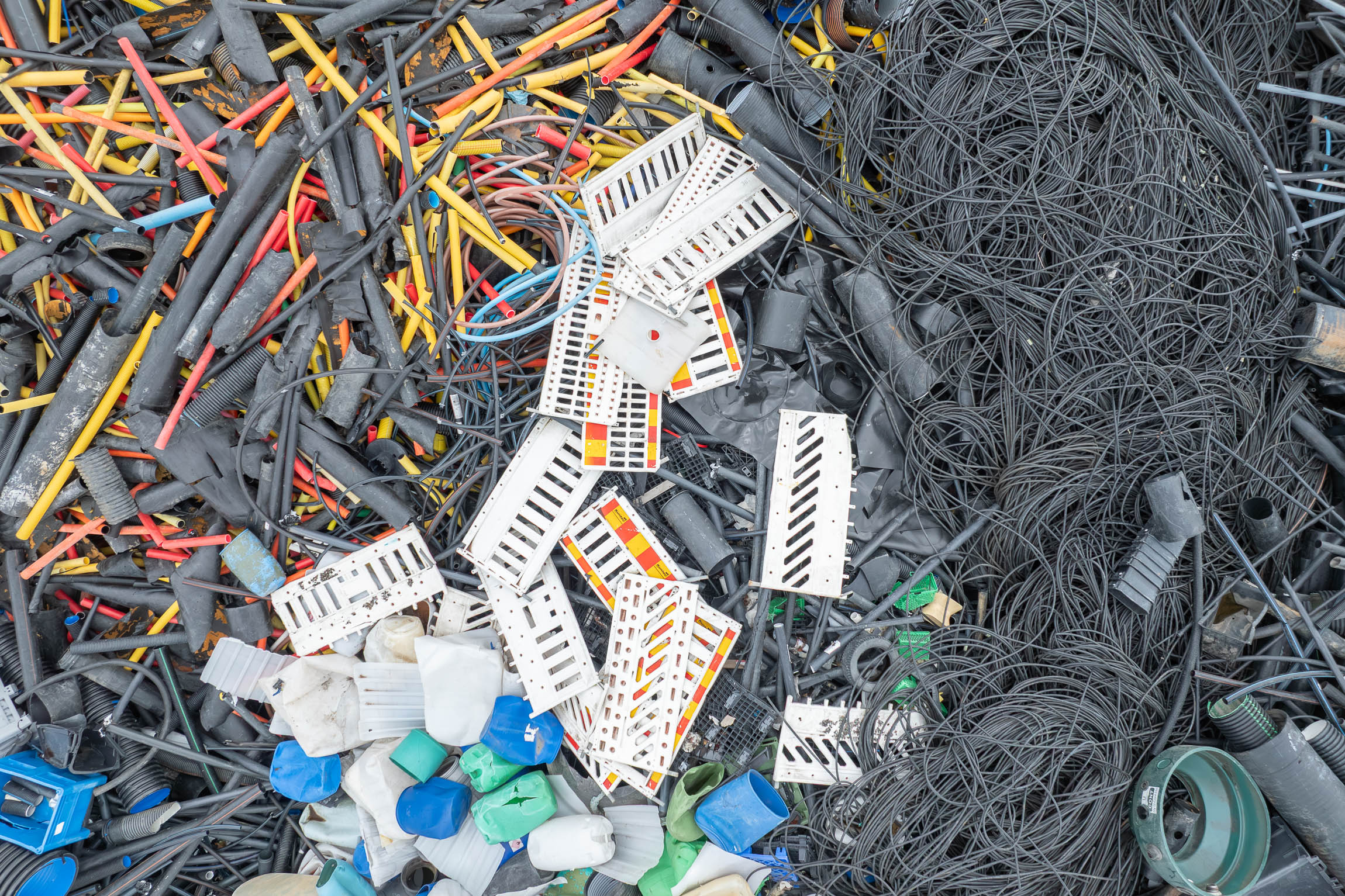 Aerial view of a mountain of hard plastic waste at a recycling plant