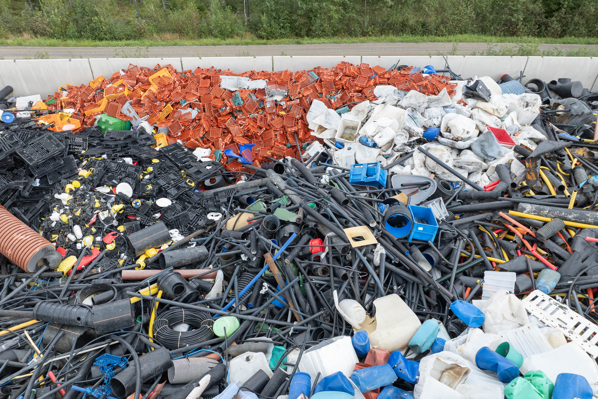 Aerial view of a mountain of hard plastic waste at a recycling plant