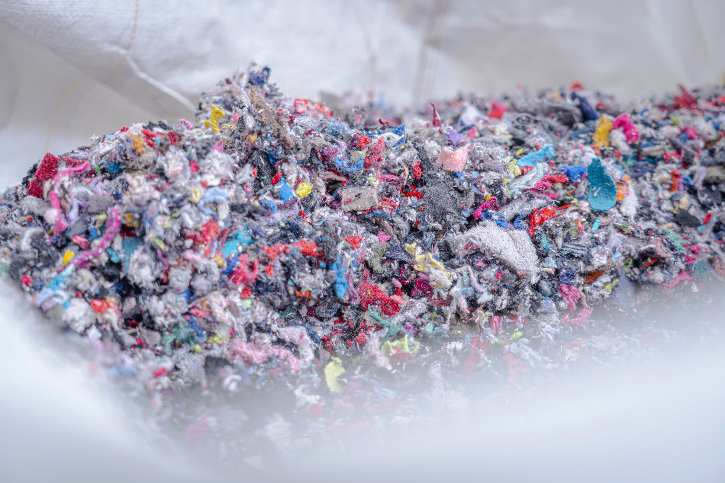 Shredded textiles in a white big bag