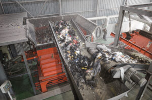 WEIMA PreCut 3000 shredder at Tosung for shredding textile waste using a fully loaded conveyor belt