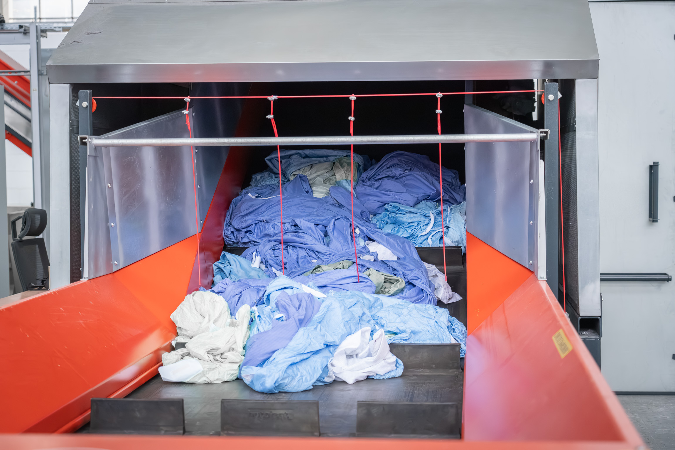 Textiles on a conveyor belt before shredding