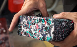 A briquette made from shredded textiles, held in the hands